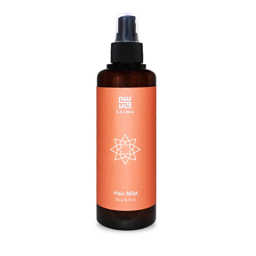 Rose and Oud Hair Mist by Salma in an amber spray bottle with an orange label, highlighting nourishing hair perfume.